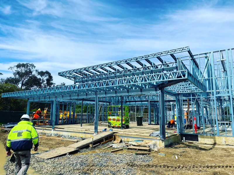 prefab steel frames and metal trusses installed by working men